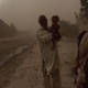 A man and children who were displaced by Islamic State of Iraq and Syria - Khorasan (ISKP) stand outside their current home during a storm on July 14, 2017, in Surkh Rod District, Afghanistan.
